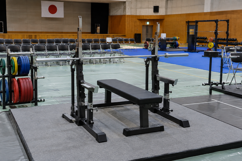 ベンチプレス大会の開始前を想起させる屋内競技会場